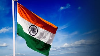 Indian flag flying against a blue sky background