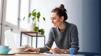 female hr manager working from home on her laptop to set up an amazon gift card incentive program