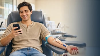 blood donor looking at his phone