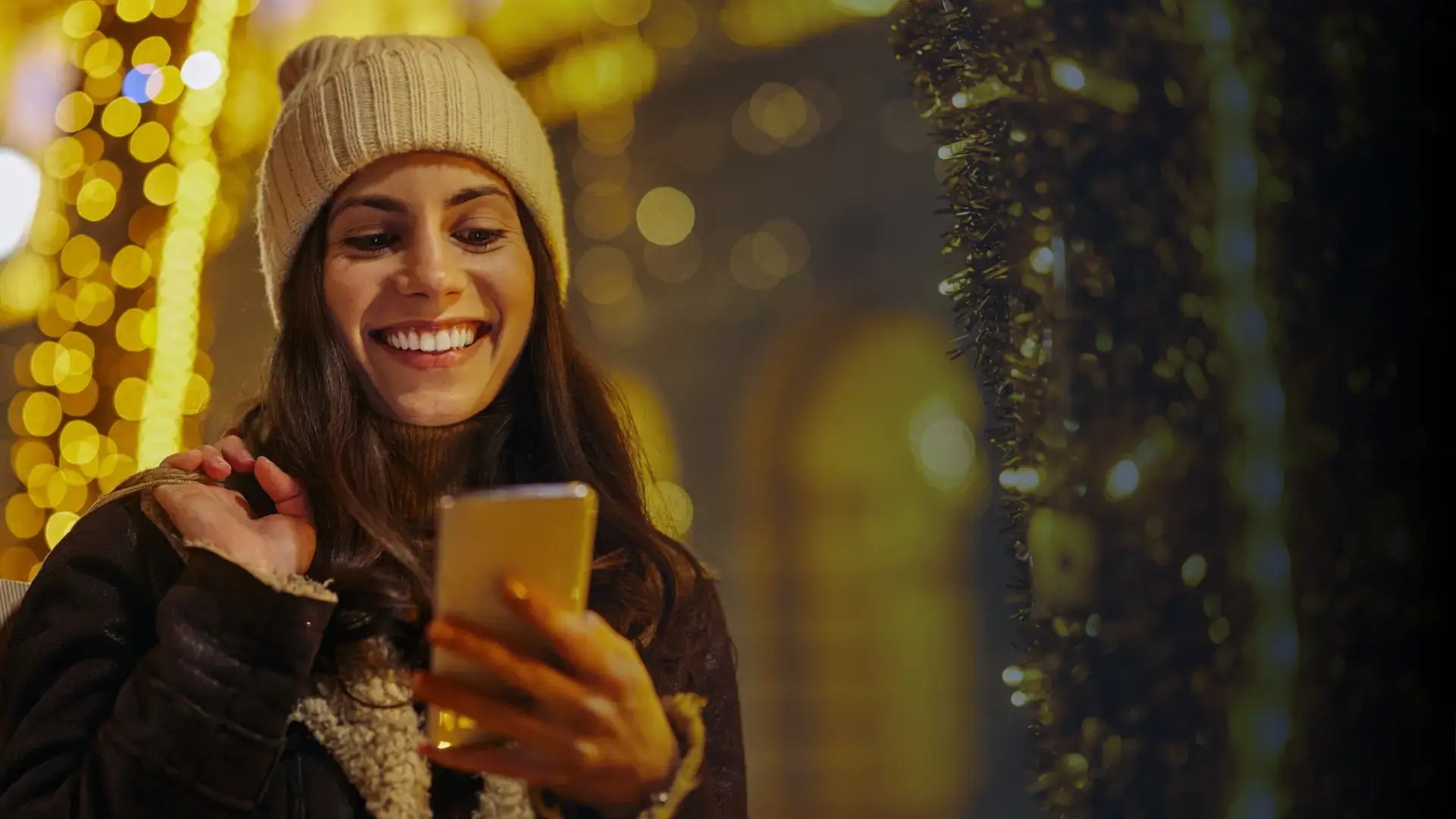 happy woman receiving a digital gift card on her phone during the holiday season