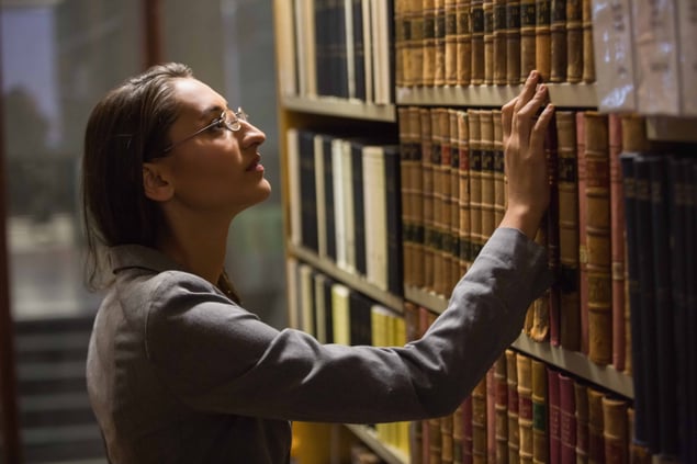 OPT Blog Image - Researcher conducting longitudinal research studies and researching at the library.