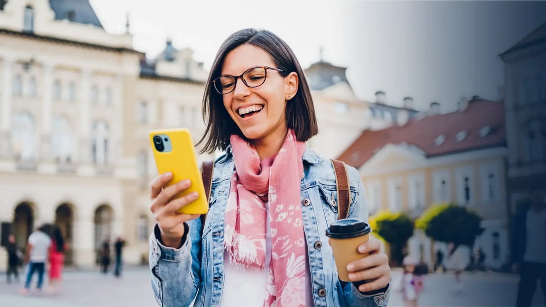 woman looking at her phone and smiling because she got a digital reward